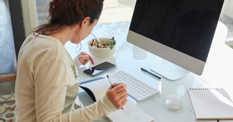 mulher fazendo anotações de multa e juros do boleto bancário