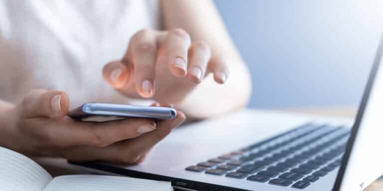 mulher ao celular consultando a lista de códigos dos bancos