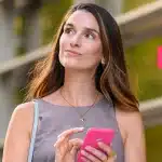 mãos de uma pessoa digitam em uma calculadora. Sobre uma mesa estão papeis e moedas, em imagem que ilustra artigo sobre crédito bancário para PJ